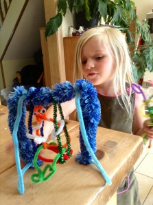 A pipe cleaner swing and person