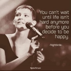 The picture is in sepia and shows Nightbirde, a young woman with short hair, standing at a microphone as if about to sing, with the words "You can't wait until life isn't hard anymore before you decide to be happy."