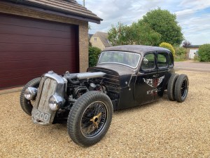 Picture shows a hotrod car parked on a gravel driveway